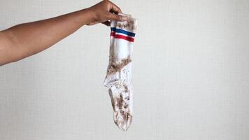 homem segurando uma sujo meias em branco fundo video