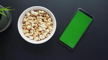 ovanifrån av smart telefon och popcorn på bordet video