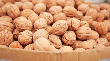 A scoop of walnuts, a superfood, rests on a stack of nuts seeds video