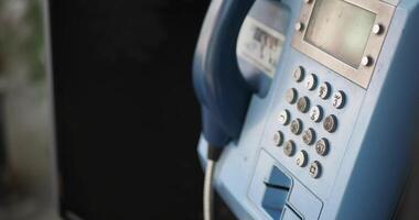 A close up of an electric blue communication device, a pay phone, video