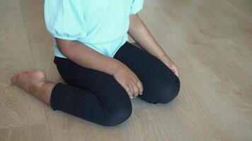 child sitting W posture on the floor . video