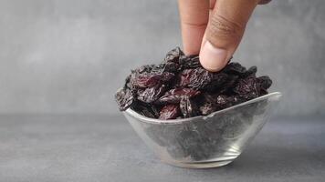 hand pick black raisin in bowl video