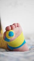 elástico terapéutico amarillo cinta aplicado a niño pierna. kinesio grabando terapia para lesión video