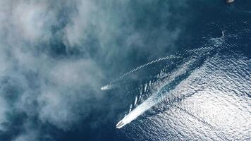 aérien bateau course. luxe croisière voyage sur bleu mer avec brumeux des nuages à ensoleillé journée. vite bateau avec blanc empreintes sur l'eau surface. paysage marin de drone. vacances, vacances et Voyage. video