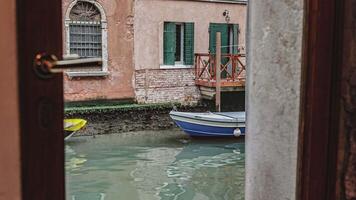 Small wooden boat moored on the river in venice video