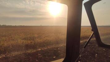 trekker ploegen de velden Bij zonsondergang video