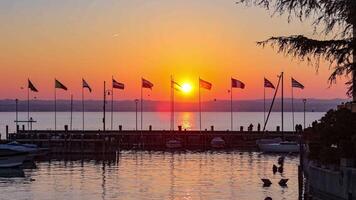 schön Sonnenuntergang Über das atemberaubend Garda See im Italien, mit das Sonne reflektieren auf das Ruhe Wasser video