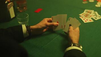 Mens handen houden poker kaarten verspreiding uit in zijn hand- de gezichten van de kaarten zichtbaar video