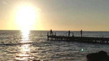 pêcheur sur le jetée à le coucher du soleil video