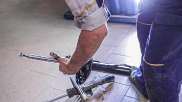 Milan Italy 29 october 2022 Mechanic hands detail during a maintenance of car suspension Car suspension replacement video