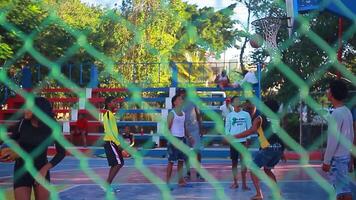 bayahibe dominicano república 22 enero 2020 negro Niños jugar vóleibol y baloncesto filmado detrás el red en el dominicano república video