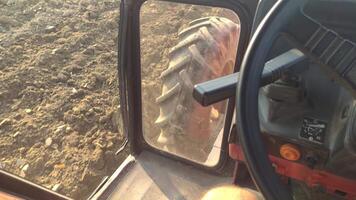 detalle de un tractor arada en el campo en granja video