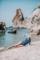 Portrait woman sea. Well looking middle aged woman with black hair, fitness instructor in blue swimwear on the rocky beach near the sea. Female fitness yoga routine concept. Healthy lifestyle. photo