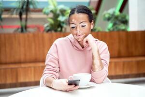 Black african american woman with vitiligo pigmentation skin problem indoor dressed pink hoodie photo