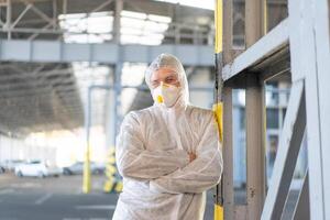 COVID-19 coronavirus doctor standing hospital parking dressed white protective overalls hazmat suit. photo