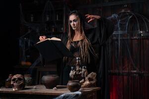 Witch in dark use spell book photo