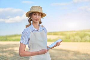 Woman farmer straw hat smart farming standing farmland smiling using digital tablet Female agronomist specialist research monitoring analysis data agribusiness photo