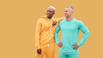 Multi ethnic friends. Two men different color black African-American ethnicity and white Caucasian ethnicity standing isolated yellow background photo