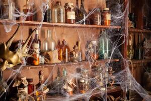 Halloween background Shelves with alchemy tools Skull spiderweb bottle with poison candles photo