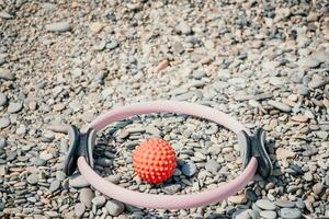 Pilates magic ring and rubber band on yoga mat near sea. Female fitness yoga concept. Healthy lifestyle harmony and meditation. photo