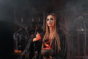 Halloween, witch use magic book and cauldron prepare poison or love potion photo