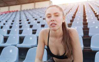 Beautiful Caucasian girl athlete holds in her hands a water in a plastic bottle photo