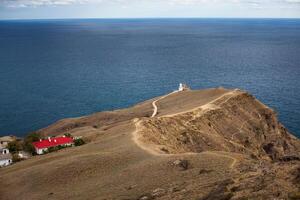 lighthouse on the mountain near the sea or ocean photo