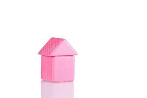 Wooden house of pink color on a white background photo