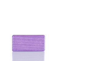 Wooden cube of purple color on a white background photo