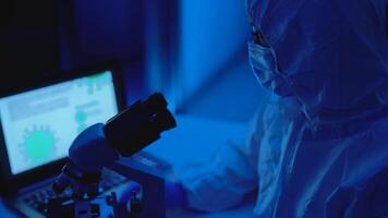 a person in a white lab coat is looking at a microscope video