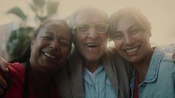 een ouder Mens en twee Dames glimlachen voor de camera video