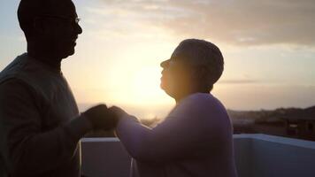 uma homem e mulher dançando em uma telhado às pôr do sol video