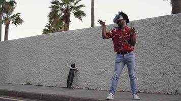 a man in a red shirt and jeans is dancing while wearing vr gear on the side of the road video