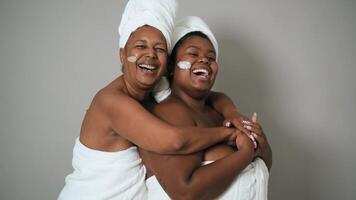 two women in towels are smiling and hugging video