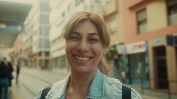 un mujer sonrisas mientras caminando abajo un calle video