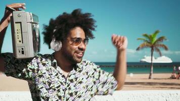 a young man holding vintage boombox is dancing and enjoying music video