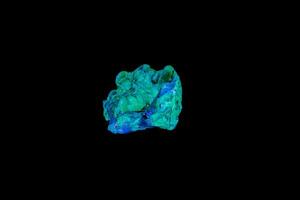 macro mineral stone opal under ultraviolet light on a black background photo