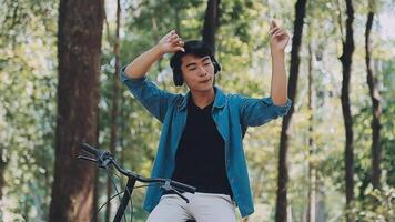 A man pushes a bicycle and walks happily to relax in the park after cycling for exercise. video