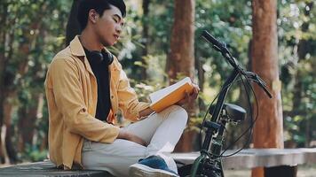 A man pushes a bicycle and walks happily to relax in the park after cycling for exercise. video