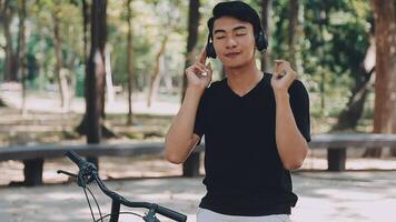 A man pushes a bicycle and walks happily to relax in the park after cycling for exercise. video