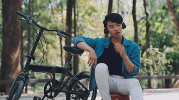 A man pushes a bicycle and walks happily to relax in the park after cycling for exercise. video