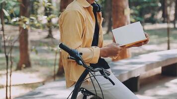 A man pushes a bicycle and walks happily to relax in the park after cycling for exercise. video