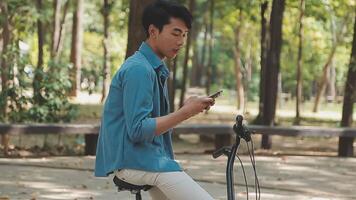 A man pushes a bicycle and walks happily to relax in the park after cycling for exercise. video