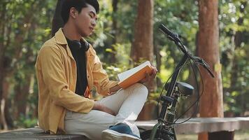 A man pushes a bicycle and walks happily to relax in the park after cycling for exercise. video