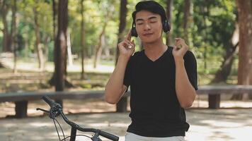 A man pushes a bicycle and walks happily to relax in the park after cycling for exercise. video