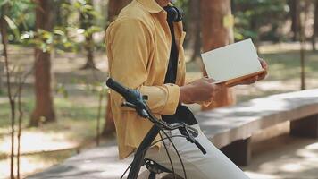 A man pushes a bicycle and walks happily to relax in the park after cycling for exercise. video