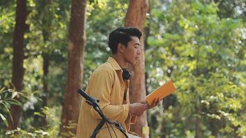 A man pushes a bicycle and walks happily to relax in the park after cycling for exercise. video