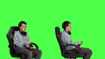 Young woman celebrating video games win against greenscreen backdrop, sitting on an office chair and playing online e sport tournament. Gamer feeling happy about winning worldwide game. Camera B.