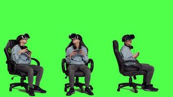 Happy gamer winning video games tournament with vr glasses, playing mobile gaming championship using her smartphone and virtual reality interactive headset. Greenscreen backdrop. Camera A.