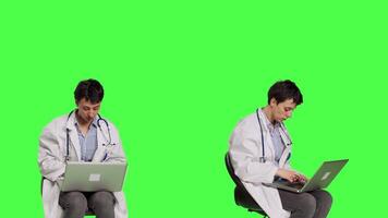 Physician doing research with a x ray scan result against greenscreen backdrop, examining radiography diagnosis to help patients with disease. Woman doctor studying radiology in studio. Camera B. video